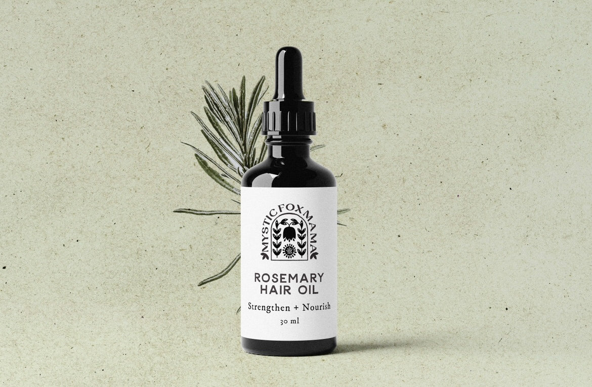 Bottle of rosemary hair oil with a dropper on a textured beige background